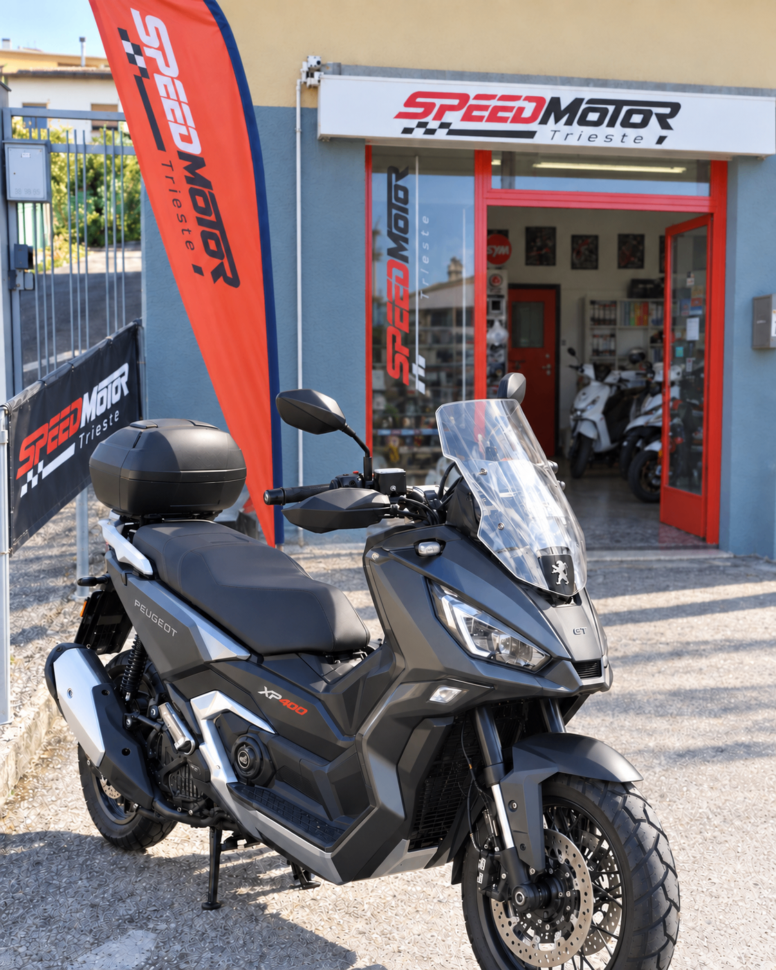 Esterno della concessionaria Speed Motor Trieste con uno scooter Peugeot XP 400